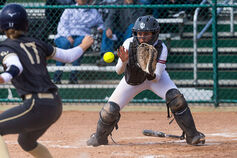A softball catcher gets ready to make a play at home plate.